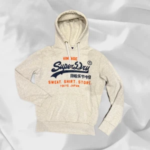 Superdry Hoodie - Fet hoodie från Superdry i grå – enkel att matcha och skön att bära. Ett stilrent val, noggrant utvalt med omsorg av AM Clothing.  📩 Frågor? Hör gärna av dig! 📲 Följ oss här på Plick för fler uppdateringar. ♻️ Tack för att du handlar mer hållbart med AM Clothing!