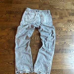Grå jeans från Zara med råa kanter - Grå jeans från Zara i rak modell med snygga råa och fransiga benslut. Klassisk femficksdesign och normal passform. Perfekta för dig som gillar en avslappnad och trendig look.