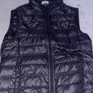 Svart dunväst från EA7 Emporio Armani - Säljer min Armani väst. Osäker på storleken men xs eller S är den. Inga skador på den
