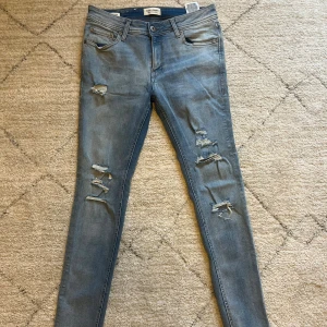 Ljusblå  jeans från Jack & Jones - Snygga ljusblå skinny jeans från Jack & Jones med slitna detaljer och hål på benen. | storlek: 31/32 | skick 7,5/10 | modell: skinny fit Liam | hör av dig vid frågor och funderingar!