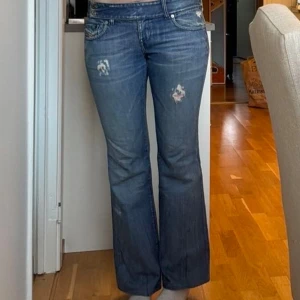 Blå bootcut jeans med slitningar - Snygga blå bootcat jeans från diesel i bra skick💕 Dem är i storlek S/M och är lite för korta för mig som är 175 cm lång! Kontakta mig för fler bilder eller funderingar 