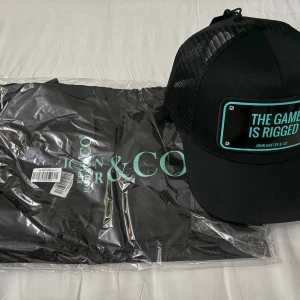 John Hateter keps - Helt ny John hatter keps, med förpackning och lappar. Nypris 800.