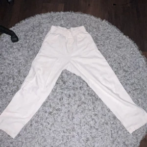 Beiga linnebyxor från H&M med snörning - Snygga beiga linnebyxor från H&M i storlek 152. Byxorna har elastisk midja med snörning och raka ben. Perfekta för en chill och avslappnad stil, med praktiska fickor på sidorna. Lätta och luftiga i materialet.