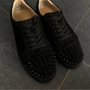 Christian Louboutin svarta sneakers med nitar - Svarta loubs me nitar. Köpta här på plick. Påsen medföljer i köpet. Är öppen för byten pris kan diskuteras. Vet ej om de är äkta  o en spik är borta!