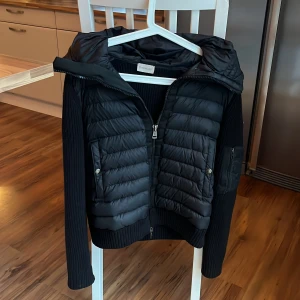 Moncler Cardigan jacka - Säljer min Moncler jacka i storlek S. Då jag är sugen på något nytt,Den är i fint skick, ser helt ny ut!  och passar perfekt nu till hösten. Stickade ärmar, fina detaljer och den klassiska Moncler-loggan gör den riktigt stilren. För mer bilder, kom privat! Priset är inte hugget i sten vid snabb affär. Bara att skriva om du har funderingar! Är även öppen för byten!