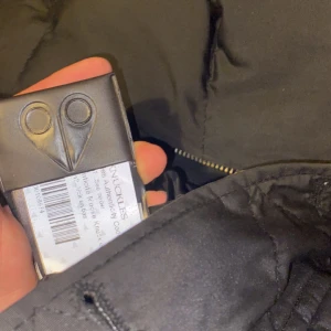 Musse jacka - Säljer en svart pufferjacka med mysig pälsdetalj på huvan. Jackan har dragkedja och knappar framtill, perfekt för kalla vinterdagar. Den är långärmad och ser riktigt varm ut. Passar både till vardags och festliga tillfällen. Hör av dig vid intresse! 🖤