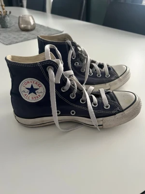 Marinblå converse - Mörkblå converse i storlek 37. De är använda och har små sprickor på sidorna (se bilder) men har mycket kvar att ge! Köp gärna bundle så kan vi komma överens om ett bra paketpris! Finns just nu fri frakt!