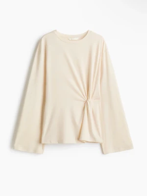 Beige långärmad topp med twistdetalj - Säljer en beige långärmad topp med rund hals och unik twistdetalj framtill. Lös/stor i storlek skulle då säga att det passar S och M (original storlek är S)