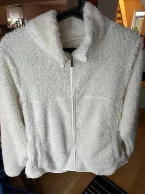 Vit teddyfleece / fluffy zip-jacka – supermjuk & mysig - Säljer en supermjuk vit teddyfleece-jacka med dragkedja framtill och hög krage. Perfekt som mysjacka hemma eller som lätt ytterplagg under höst/vår. Skön fluffig struktur och figursydd passform. I fint skick. 🤍