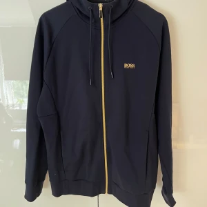 Mörkblå Bosströja - Säljer en mörkblå bosströja i storlek M. Säljes pga för stor och aldrig använd. Nypris 2000kr mitt pris är 800kr. 