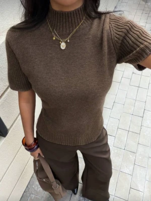 Brun ribbad polotopp - Snygg brun polotopp med ribbade detaljer på ärmar och hals. 