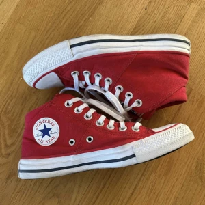 Röda converse - Säljer ett par superfina Mid converse i röd. Dom är köpta i USA. Dom är använda cirka 5 gånger, men i väldigt fint skick och har inga slitningar. Storlek:36,5. Nypris: 670kr. 