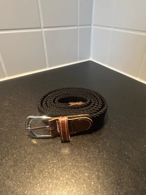 Svart bälte  - Flätat bälte  105 cm men väldigt töjbart så passar även bredare  Fler bruna detaljer   MER MÄRKESKLÄDER I PROFILEN 