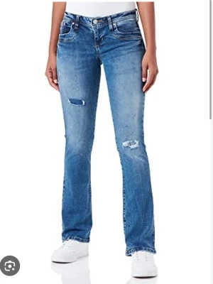 Blå bootcut jeans från LTB - Säljer ett par blå bootcut jeans med slitna detaljer på låren och knäna från LTB. Jeansen är i modellen Valarie! Jeansen har klassisk femficksmodell, låg midja och är tillverkade i denim. Perfekta till sneakers eller boots för en avslappnad look. 