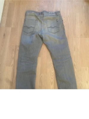 Replay ljusblå jeans straight fit - Säljer ett par gråa jeans från Replay med klassisk femficksdesign och diskreta slitningar framtill. Jeansen har rak passform och normal midja, perfekta till en avslappnad stil. Materialet är mjukt jeans-tyg som ger en skön känsla hela dagen. Passar dig som är runt 170