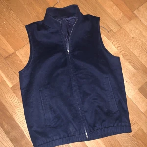Mörkblå ullväst från Suitsupply - Snygg mörkblå väst från Suitsupply i ull med slät yta och fodrad insida. Perfekt för lager-på-lager och stilrena outfits. Nypris är 3999 jag säljer för endast 1000
