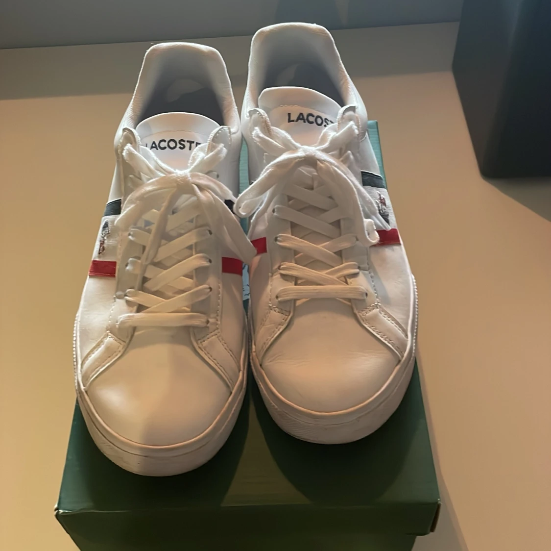 Vita Lacoste sneakers med röd och blå detalj