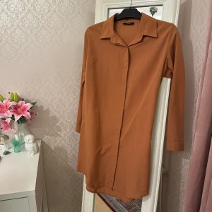 Brun skjorta - Snygg ljus brun skjorta med klassisk krage och knappar framtill. Aldrig använd. Köpt utomlands så storleken på lappen är inte i EU, men den passar bra som en S, bredden är 50cm 🫶🏼