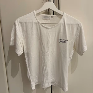 Vit t-shirt från Marc O'Polo Jeans - Vit t-shirt från Marc O'Polo Jeans med rund hals och korta ärmar. Diskret broderad logga i blått på bröstet. Mjuk och skön bomullskvalitet.