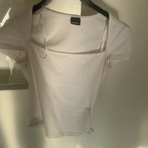 Vit kortärmad topp från Gina Tricot - Säljer en stilren vit topp från Gina Tricot i storlek S. Toppen har korta ärmar, rundad hals och är gjord i mjuk bomull. Perfekt för dig som gillar enkla och cleana plagg med en klassisk vibe. Passformen är normal och toppen är lätt att matcha med allt.