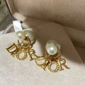 Dior örhängen med pärlor och guld - Supersnygga örhängen från Dior med stora och små pärlor i vitt. Bokstäverna D-I-O-R i guld hänger under pärlorna, där O:et är täckt av glittrande stenar. Perfekt statement-accessoar för dig som gillar lyxig vibe.
