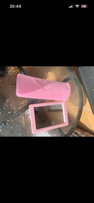 Rosa sminkspegel med fodral - Säljer en smidig sminkspegel med ljusrosa ram och tillhörande mjukt fodral i rosa tyg. Perfekt storlek för att ha med i väskan och enkel att använda när du fixar sminket. Spegeln är rektangulär och har en stilren design. Kudden är använd och har fläckar på sig spegeln är helt ny 
