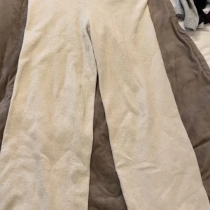 Beiga stickade byxor med loose fit - Mysiga och sköna beiga stickade byxor med rak passform och loose fit. Perfekta för chill dagar hemma eller när du vill vara extra bekväm. Materialet är mjukt och värmande fleece i en ljus beige ton. Pris kan diskuteras och köparen står för frakt