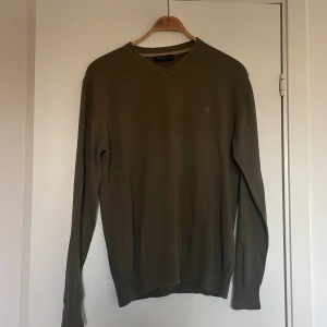 Olivgrön stickad tröja från Berga - Olivgrön stickad tröja från Berga i storlek XL. Tröjan har v-ringad hals och långa ärmar, perfekt för dig som gillar enkel och stilren design. Materialet är mjukt och skönt, och färgen är lätt att matcha med jeans eller chinos.