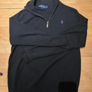Svart half zip tröja Polo Ralph Lauren - Svart långärmad tröja från Polo Ralph Lauren med ett litet hål på armen 