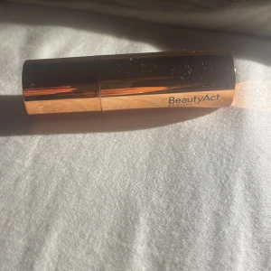 BeautyAct Mañana stick foundation - Foundationstick från BeautyAct i nyansen Mañana. Kommer i en lyxig, guldskimrande hylsa och är enkel att applicera direkt på huden. Krämig formula som smälter in och ger en jämn finish. Perfekt att ha med i väskan för touch-ups under dagen.