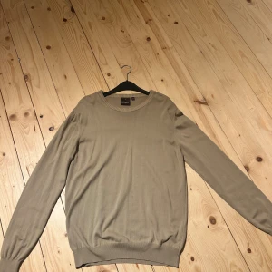 Beige stickad tröja Oscar Jacobson - Snygg beige stickad tröja från Oscar Jacobson i storlek L. Tröjan har rund halsringning med ribbad kant och långa ärmar. Tillverkad i Italien, perfekt för dig som gillar stilrena och klassiska plagg med skön passform. Använd 1 gång, passade inte mig där av säljer jag den. Hör av dig ifall du har några frågor!