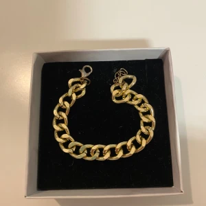 Guld Armband - 17cm. Snyggt chunky armband med breda guldfärgade länkar och karbinlås. Kedjan har en klassisk design som ger en cool och trendig vibe. Perfekt att kombinera med andra smycken för en personlig stil. PRISET KAN DISKUTERAS.