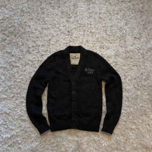 Mörkgrå stickad kofta/cardigan från hollister - Sjukt fet o limiterad cardigan/hoodie från hollister, den är använd men i mycket bra skick utan defekter. , tveka inte på o skriva vid fler frågor!