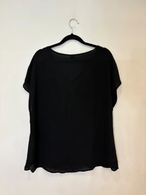 Svart v-ringad blus från Shein - Svart blus från Shein med v-ringning och korta ärmar. Tunt, lätt material som ger en flowy känsla. Perfekt för dig som gillar en enkel men snygg look. Passar till många olika outfits och är lätt att matcha.