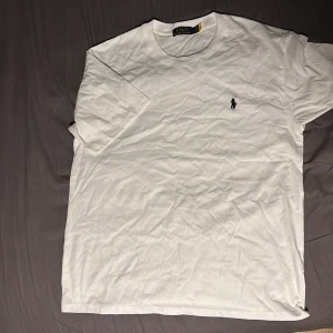 Ralph Lauren T-shirt - Snygg ralph lauren T-shirt, vit med svart logga, fint skick, storlek L, hör av dig vid funderingar!