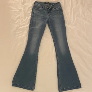 Lågmidjade Hollister jeans - Jättefina, ljusblåa, lågmidjade flare jeans från Hollister i storlek 00R, W23, L32. Skulle säga att de motsvarar storlek XS!😊