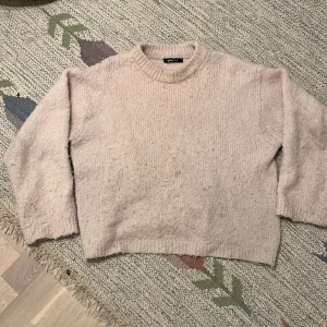 Rosa stickad tröja Gina Tricot XS - Mysig rosa stickad tröja från Gina Tricot i storlek XS. Tröjan har en rund halsringning och långa ärmar med ribbade muddar. Perfekt för att hålla sig varm under kyliga dagar och har en enkel, clean look som funkar till jeans eller kjol. Har en lite fläk på framsidan.