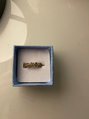 Guldfärgad ring med blommor - Superfin guldfärgad ring med små blommor runt hela ringen. Perfekt detalj för att lyfta din stil och ge en söt touch till dina outfits.