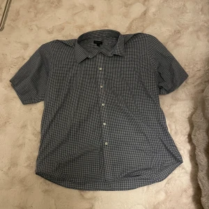 Blårutig kortärmad skjorta från Berga - Snygg blårutig skjorta från Berga i storlek XXL med klassisk krage och korta ärmar. 