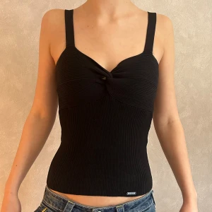 Ribbad topp Guess - En svart ribbad topp från Guess. Står ingen storlek, men uppskattas som en XS/ S! Fint skick, något nopprig på framsidan. Skriv vid frågor/ funderingar/ mått!😄 PRISET ÄR ALLTID DISKUTERBART!☺️