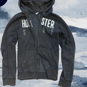 Mörkgrå hoodie från Hollister S/M  - Säljer nu denna skitsnygga mörkgråa hollister tröjan i toppskick! Längd 68 cm| axelbredd 42 cm| skriv vid fler frågor eller funderingar. Priset går att diskutera vid snabb affär!