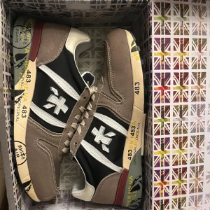 Premiata sneakers i beige och svart - Snygga sneakers från Premiata med beige mockadetaljer, svart textil och vita skinnpartier. Helt nya!