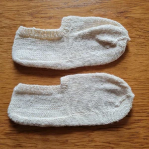Handstickade låga sockor strl 41-43 - Ett par vita handstickade låga sockor. Materialet är stickat och känns skönt mot huden. Storlek 41-43.