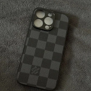 iPhone 16 Pro Skal Louis Vuitton Stil - Elegant skal till iPhone 16 Pro i klassiskt Louis Vuitton-mönster. Ger ett lyxigt och stilrent skydd till din mobil. Skalet är i nyskick utan synligt slitage och har exakta utskärningar för kameror och knappar.
