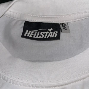 Vit Hellstar t-shirt med tryck - Vit t-shirt från Hellstar med svart grafiskt tryck på både fram- och baksidan. Klassisk passform med rund hals och korta ärmar. Perfekt för folk som gillar streetwear
