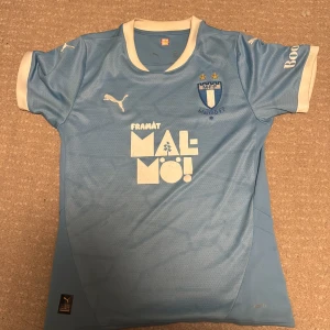 Malmö FF matchtröja från 2025 - Senaste säsongens äkta Puma-tröja i ikonisk himmelsblå färg. Lätt och ventilerande dryCELL-material med broderat klubbmärke och stjärnor ✨ Perfekt mix av sport och street, lika snygg på match som till vardags. Jag har inte tränat i den någonting bara haft den till vardags några gånger.