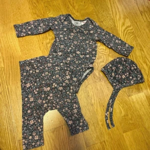 Mörkblommiga leggings för baby- 1-3 mån/ 56 cm  - Supersöta leggings i mörk botten med rosa och ljusbruna blommor. Mjukt bomullsmaterial som är skönt mot huden. Perfekt för dig som gillar gulliga och trendiga prints till de minsta. Matchar body och mössa i samma mönster.