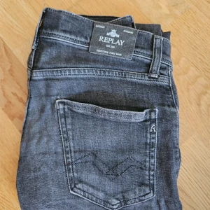 Replay svarta jeans i slim fit - Snygga svarta jeans från Replay med klassisk femficksdesign och diskreta sömmar på bakfickorna. Jeansen har en slim passform och är tillverkade i ett mjukt och stretchigt jeansmaterial som sitter skönt hela dagen.