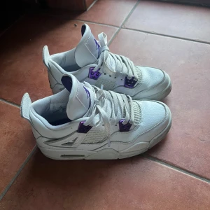 Nike Air Jordan 4 vit/lila sneakers - Nike Air Jordan 4 sneakers i vitt , använt några gånger men är fortfarande i bra skick, pris kan diskuteras 