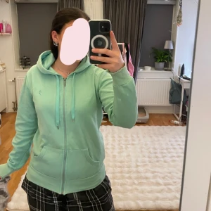Mintgrön hoodie med dragkedja - Säljer en mintgrön hoodie. Sliten i kanten på ärmarna men fin i övrigt💗